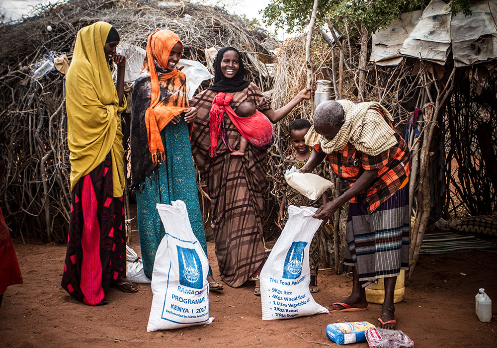Crianças a beber água de uma bomba manual